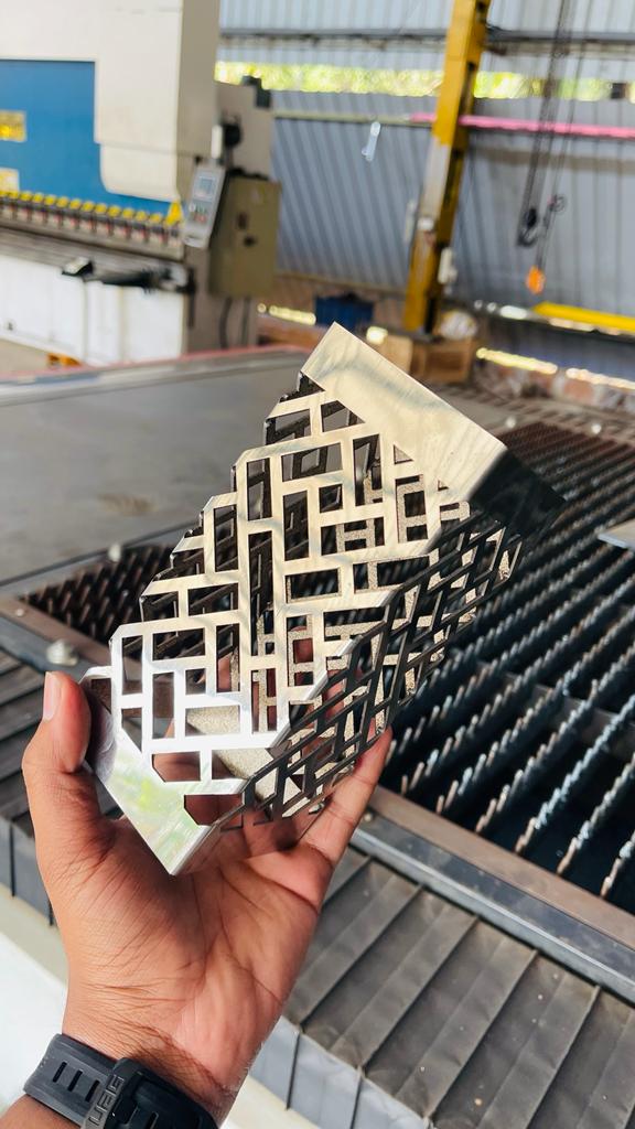 Freshly cut interlocking pattern part held over the laser bed