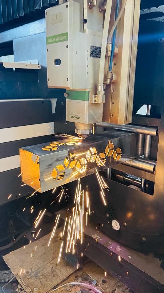 Laser cutting head cutting a steel tube with sparks